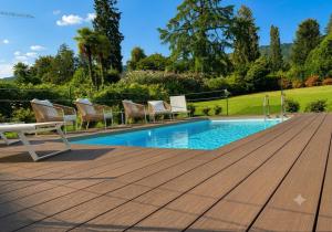 a swimming pool with chairs next to a wooden deck at Villa Valesca in Stresa