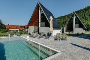 a swimming pool in front of a house with a church at Diamond Hill Houses in Praid