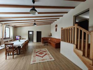 a living room with a table and a couch at Gyulak Guesthouse in Izvoare