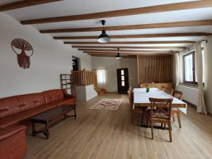 a living room with a table and a couch at Gyulak Guesthouse in Izvoare