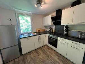 a small kitchen with white cabinets and a window at Monteurunterkunft Mosbach in Mosbach