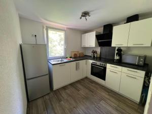 a kitchen with white cabinets and a white refrigerator at Monteurunterkunft Mosbach in Mosbach