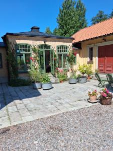ein Haus mit Topfpflanzen davor in der Unterkunft Ängbacka in Rejmyre