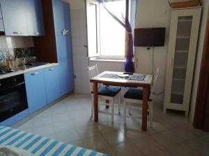 a small kitchen with a table and chairs and a window at Casetta Calanave in Ventotene