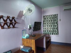 a room with a desk with a fan and a window at Saran Resort room 3 in Ban Khok Wat