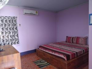 a bedroom with a bed in a room with a window at Saran Resort room 3 in Ban Khok Wat