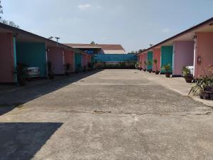 an empty parking lot in front of a row of houses at Saran Resort room 3 in Ban Khok Wat