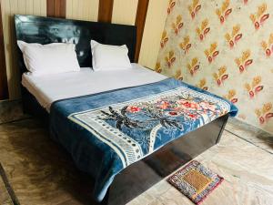 a bedroom with a bed with a blue blanket on it at Kaushalya River View in Solan