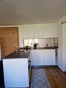 a kitchen with white cabinets and a counter top at Waldnest in Grächen