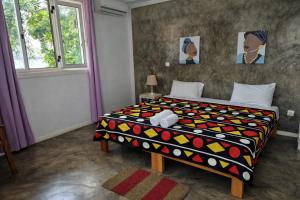 a bedroom with a bed with a colorful comforter at Hotel PZero in São Tomé