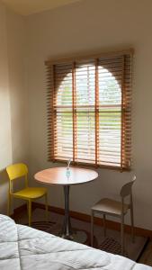 a room with a table and two chairs and a window at โรงแรม JP Lucky Lux Hotel in Ban Nong Samran