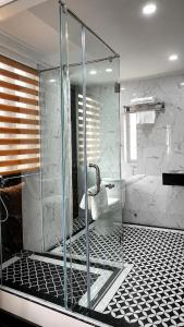 a bathroom with a glass shower with a toilet at The 39 Lane Hotel Hanoi in Hanoi