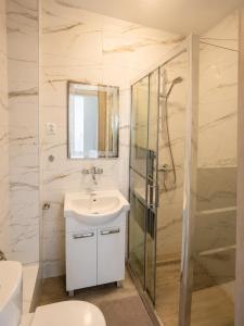 a white bathroom with a sink and a shower at Magnat Dźwirzyno in Dźwirzyno +41 photos