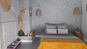 a bedroom with a bed with a yellow bedspread at les hirondelles de Barrou in Saint-Jean-de-Barrou