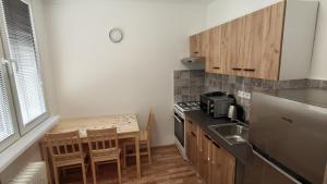 a small kitchen with a table and a stove top oven at Apartmán pro 3 osoby, Most M3 in Most
