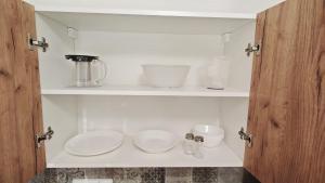 a kitchen with a white cabinet with dishes on it at Apartmán pro 3 osoby, Most M3 in Most