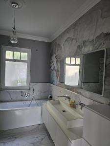 a bathroom with a tub and a sink and a mirror at Villa Beckurts in Wernigerode +38 photos