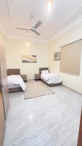 a room with two beds and a chalkboard on the wall at شقق مفروشة الباحة in Al Baha