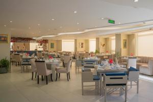 a dining room with tables and chairs in a restaurant at Armada Avenue Hotel Amman in Amman