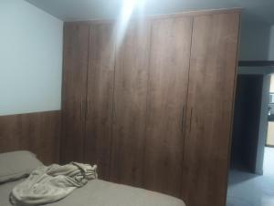 a bedroom with a large wooden cabinet next to a bed at Casa Aconchegante in Barbacena