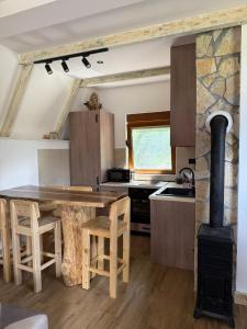 a kitchen with a wooden table and a stove at Zelena dolina Zminica in Zminica