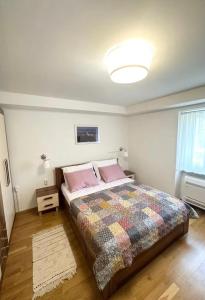 a bedroom with a large bed with pink pillows at Apartman Batelan in Brseč