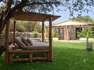 a wooden pergola with a bench in a yard at Songes d’été in Bonifacio