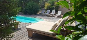 a pool with a couch and chairs next to it at Songes d’été in Bonifacio
