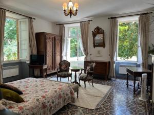 a bedroom with a bed and a table and windows at LA SEIGNEURIE DE TILLAC in Tillac +66 photos