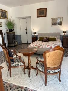 a bedroom with a bed and a table and chairs at LA SEIGNEURIE DE TILLAC in Tillac