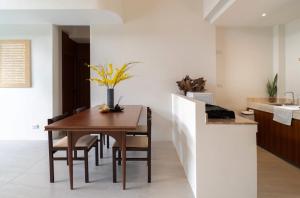a kitchen and dining room with a wooden table and chairs at Villa Mar Pool Villa in Sathani Hat Yai