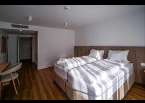 a large bed in a room with a wooden floor at Hanul Pelerinului Cepari in Cepari Ungureni