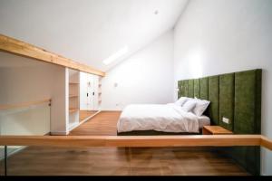 a bedroom with a bed with a green headboard at Hanul Pelerinului Cepari in Cepari Ungureni
