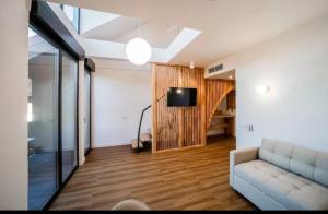a living room with a couch and a tv at Hanul Pelerinului Cepari in Cepari Ungureni