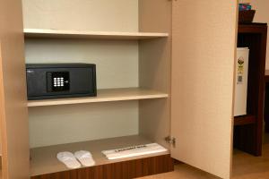 a room with a small tv on a shelf at Clickon Value Seven Hills in Chik Bānavar +1 photo