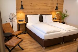 a bedroom with a large bed and a chair at HOTEL MARIA in Gramatneusiedl +91 photos