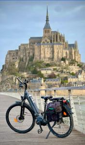 a bike parked on a bridge with a castle in the background at Hotel Rose in Beauvoir