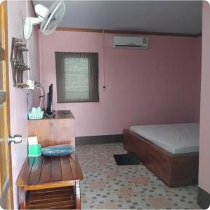 a bedroom with a bed and a desk and a table at Saran Resort room 4 in Ban Khok Wat
