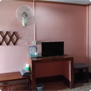 a room with a desk with a television and a fan at Saran Resort room 4 in Ban Khok Wat