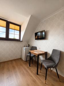a room with a table and chairs and a refrigerator at Magnat Dźwirzyno in Dźwirzyno