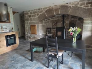 a kitchen with a table and a stone wall at Chambre d'hôte lozérienne in Saint-Privat-du-Fau