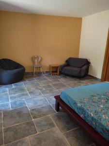 a room with a bed and a couch and a table at Chambre d'hôte lozérienne in Saint-Privat-du-Fau