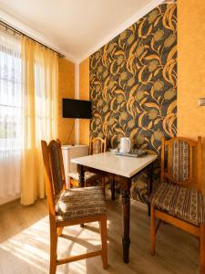 a dining room with a table and chairs and a wall at Magnat Dźwirzyno in Dźwirzyno