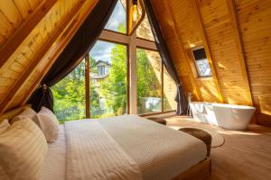 a bedroom with a bed and a tub and a window at The Cliff Village in Comarnic +122 photos