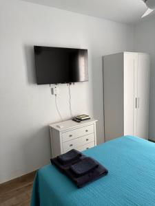 a bedroom with a bed with a tv on the wall at Marina Beach-Apartamentos Tahiche in Costa Teguise