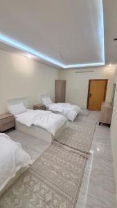 a room with three beds and a rug at شقق مفروشة الباحة in Al Baha