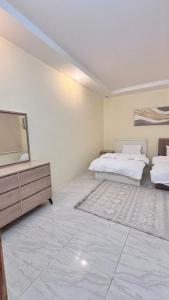a bedroom with a bed and a dresser and a television at شقق مفروشة الباحة in Al Baha