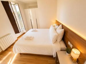 a bedroom with a large bed with white sheets and pillows at Van Gogh's Garden in Auvers-sur-Oise