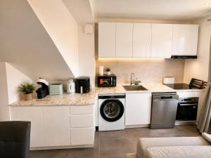 a kitchen with white cabinets and a dishwasher at Van Gogh's Garden in Auvers-sur-Oise