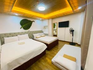 a hotel room with two beds and a tv at Nica's Palace Baguio in Baguio